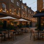 Outdoor seating area with tables and chairs at a restaurant with a cool cental London vibe